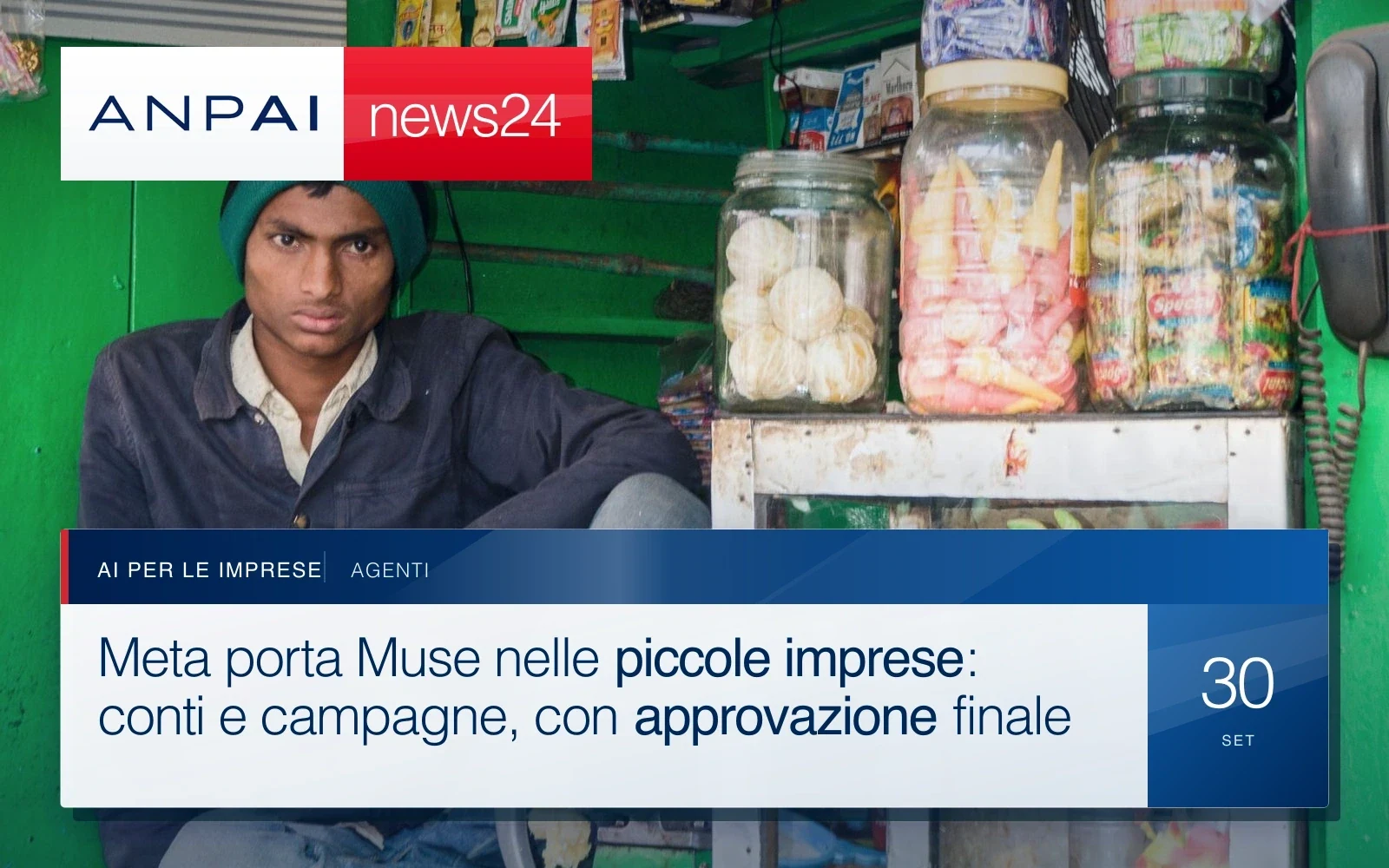 Un negoziante siede all’interno del proprio piccolo emporio, circondato dagli scaffali di prodotti.