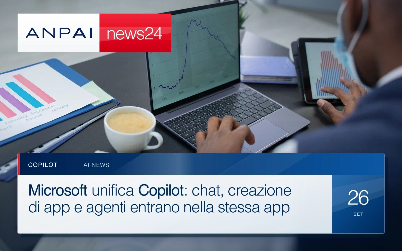Persona al lavoro davanti a un portatile e a un tablet con grafici sullo schermo.
